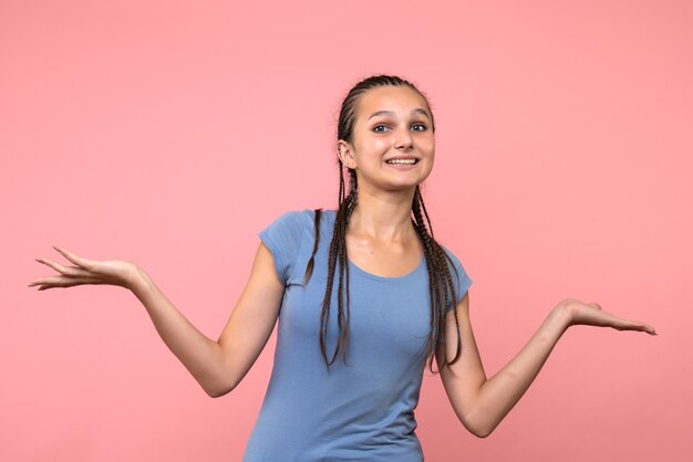 Vista frontal de la mujer joven sonriendo en rosa