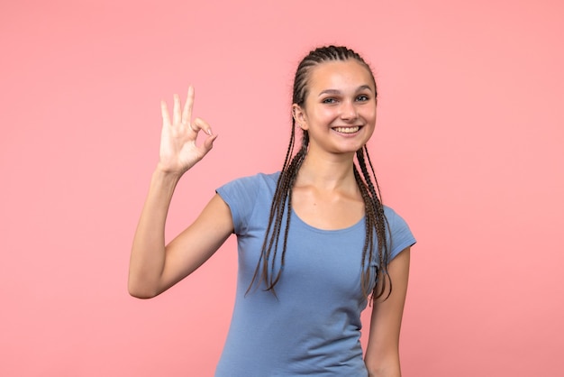 Vista frontal de la mujer joven sonriendo en rosa