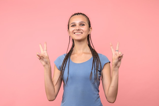 Vista frontal de la mujer joven sonriendo en rosa