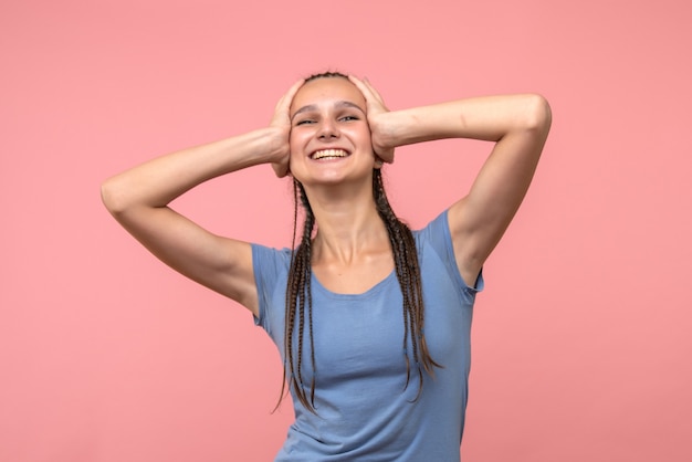 Vista frontal de la mujer joven sonriendo en rosa