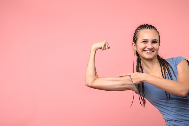 Vista frontal de la mujer joven sonriendo en rosa