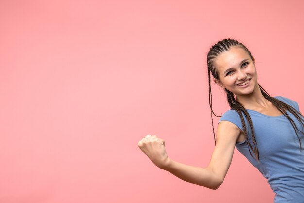 Vista frontal de la mujer joven sonriendo en rosa