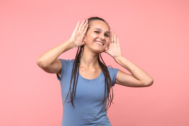 Vista frontal de la mujer joven sonriendo en rosa