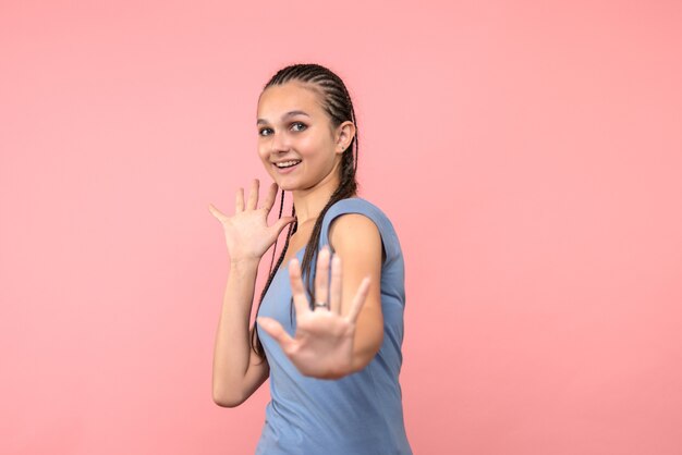 Vista frontal de la mujer joven sonriendo en rosa