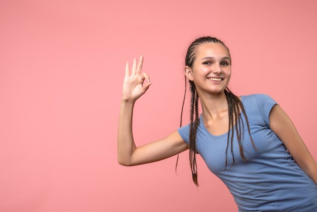 Vista frontal de la mujer joven sonriendo en rosa