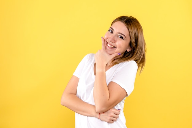 Vista frontal, de, mujer joven, sonriente, en, pared amarilla