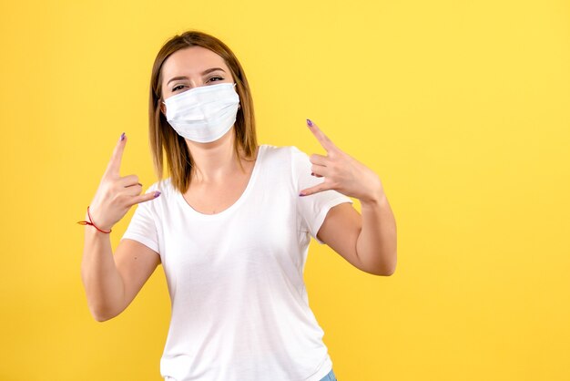 Foto gratuita vista frontal, de, mujer joven, sonriente, en, pared amarilla