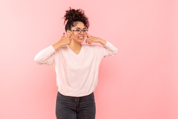 Vista frontal, de, mujer joven, sonriente, en, pared rosa