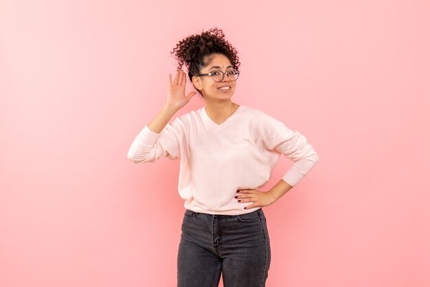 Vista frontal, de, mujer joven, sonriente, en, pared rosa