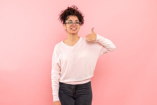 Vista frontal, de, mujer joven, sonriente, en, pared rosa