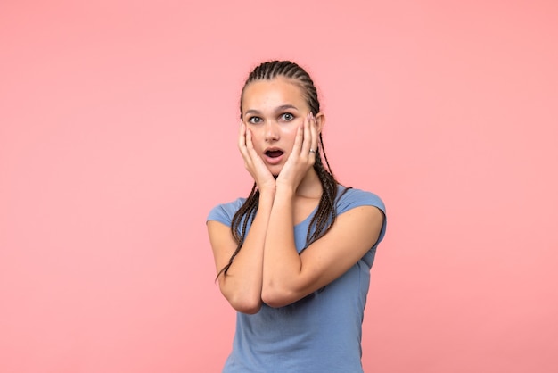 Vista frontal de la mujer joven sorprendida en rosa