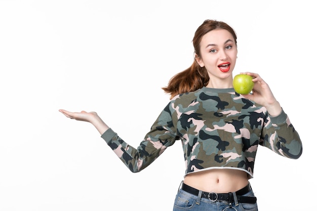 Vista frontal mujer joven sosteniendo manzana verde fondo blanco dieta horizontal salud piel salud plato jugo de fruta
