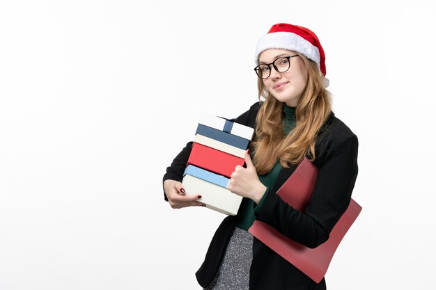 Vista frontal mujer joven sosteniendo regalos navideños en regalos de pared blanca Navidad año nuevo