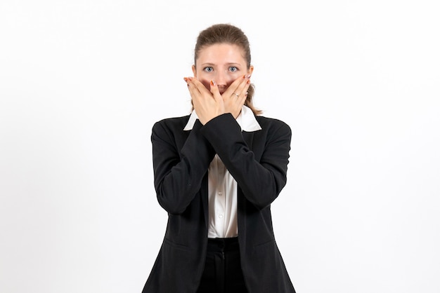 Vista frontal mujer joven en traje clásico estricto posando sobre fondo blanco mujer de negocios trabajo traje de trabajo femenino