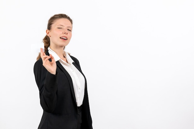 Vista frontal mujer joven en traje clásico estricto posando sobre un fondo blanco trabajo negocio trabajo traje mujer