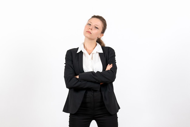 Vista frontal mujer joven en traje clásico estricto posando sobre fondo blanco traje mujer de negocios trabajo trabajo femenino