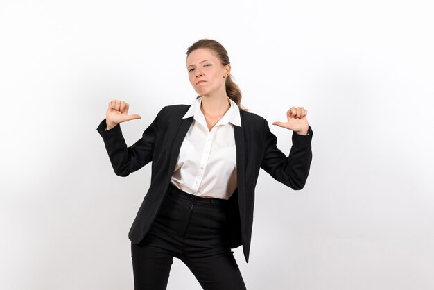 Vista frontal mujer joven en traje clásico estricto posando sobre fondo blanco traje mujer de negocios trabajo trabajo femenino