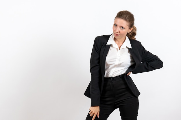 Vista frontal mujer joven en traje clásico estricto posando sobre fondo blanco traje de negocios trabajo mujer trabajo femenino