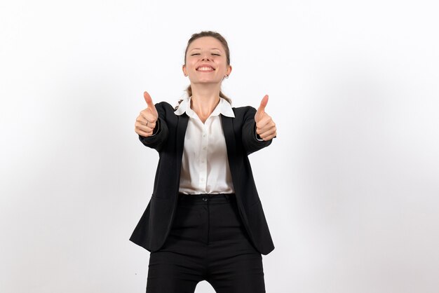 Foto gratuita vista frontal mujer joven en traje clásico estricto posando y sonriendo sobre el fondo blanco trabajo de mujer traje de trabajo femenino de negocios