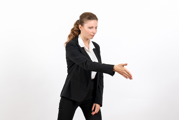 Vista frontal mujer joven en traje clásico estricto saludando a alguien sobre fondo blanco mujer de negocios trabajo traje de trabajo femenino