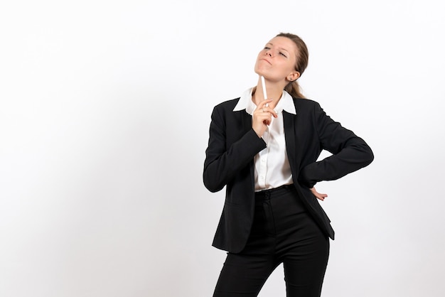 Foto gratuita vista frontal mujer joven en traje clásico estricto sosteniendo la pluma y pensando sobre fondo blanco trabajo de mujer traje de trabajo femenino de negocios