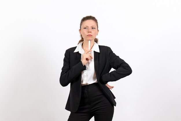 Vista frontal mujer joven en traje clásico estricto sosteniendo la pluma sobre fondo blanco mujer trabajo negocio trabajo femenino traje