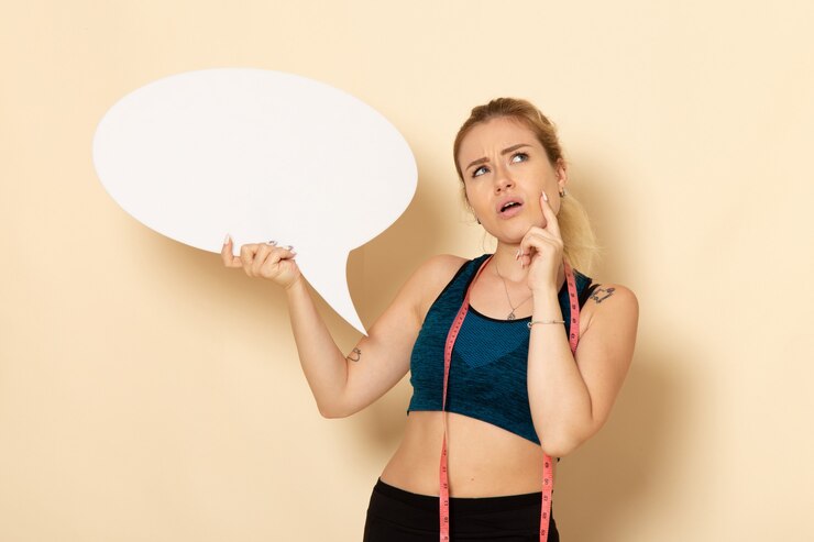 Foto gratuito vista frontal mujer joven en traje de deporte con cartel blanco y pensando