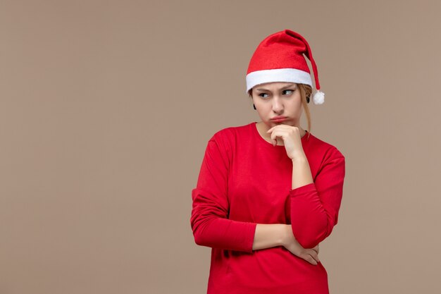 Vista frontal de la mujer joven triste con capa de navidad en marrón