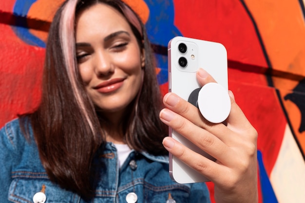 Vista frontal mujer joven usando popsocket