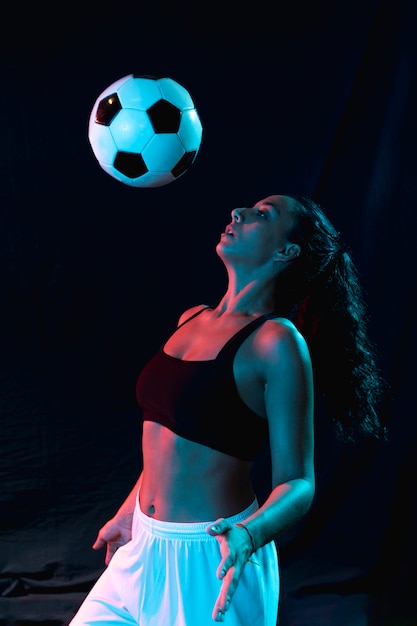 Foto gratuita vista frontal mujer jugando con balón de fútbol