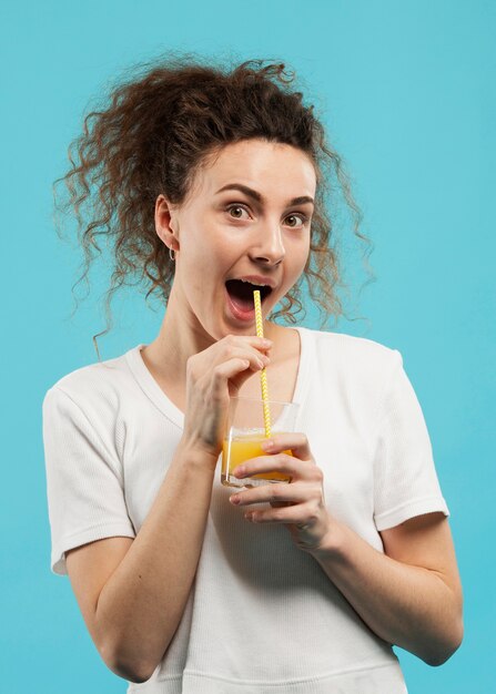 Vista frontal de la mujer con jugo de naranja