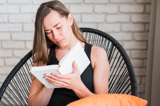 Vista frontal de la mujer leyendo un libro