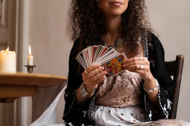 Foto gratuita vista frontal mujer leyendo tarot en casa