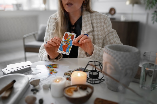 Vista frontal mujer leyendo tarot en casa