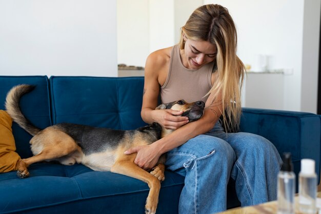 Foto gratuita vista frontal mujer con lindo perro en casa