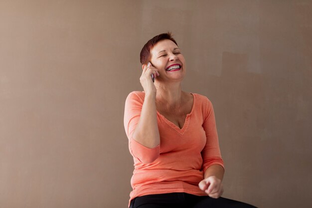 Vista frontal mujer madura hablando por teléfono