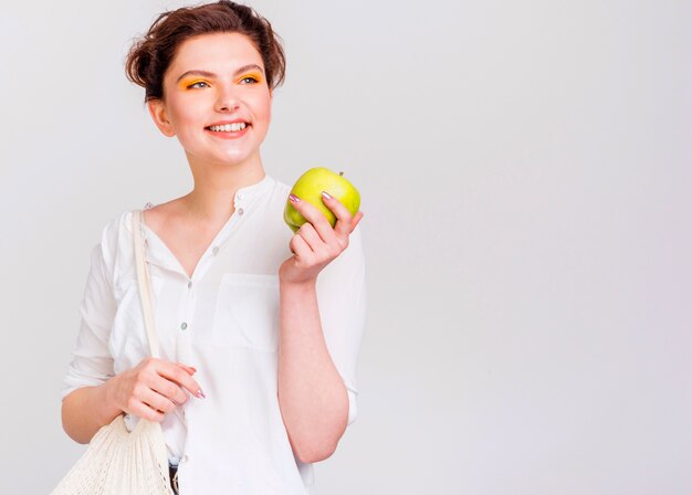 Vista frontal de la mujer con manzana verde