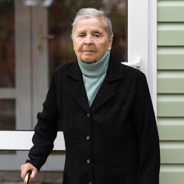 Vista frontal de la mujer mayor con bastón en el hogar de ancianos