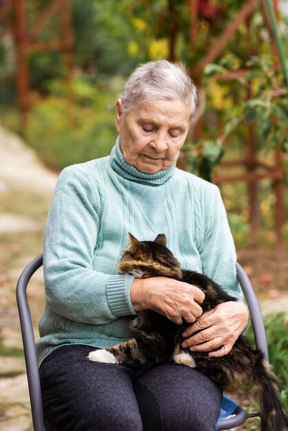 Vista frontal de la mujer mayor con gato en el hogar de ancianos