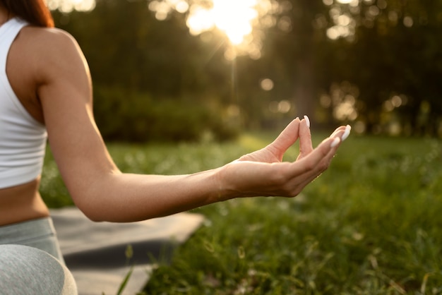 Foto gratuita vista frontal mujer meditando en la naturaleza