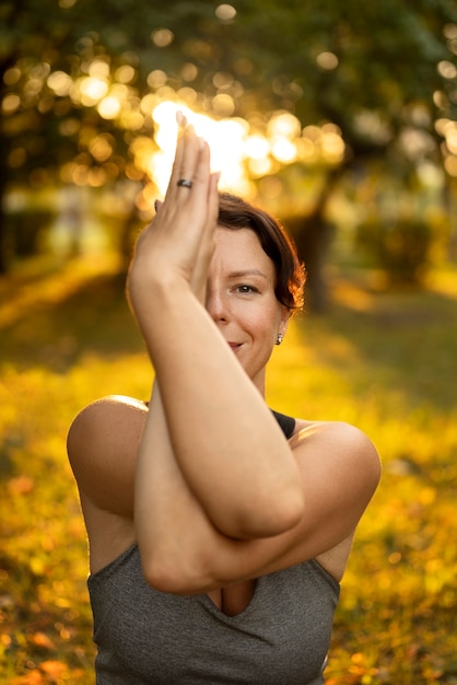 Foto gratuita vista frontal mujer meditando en la naturaleza