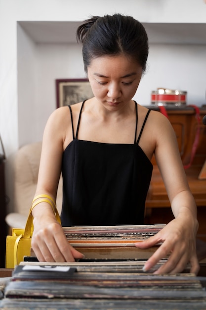 Foto gratuita vista frontal mujer mirando discos de vinilo