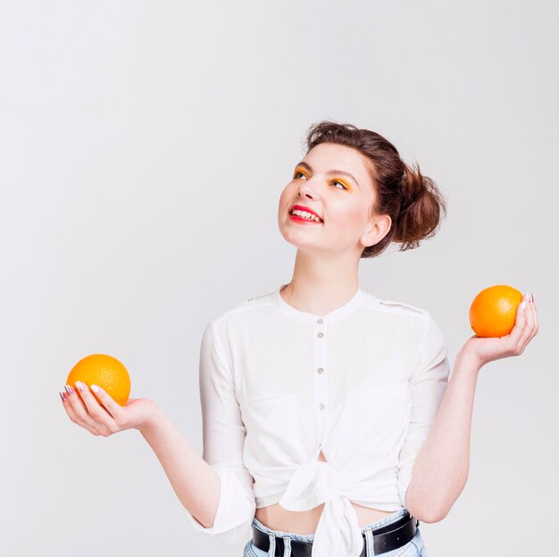 Vista frontal de mujer con naranjas