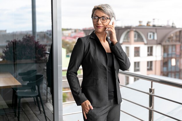 Vista frontal mujer de negocios hablando por teléfono