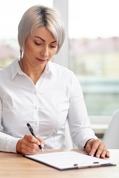 Foto gratuita vista frontal mujer de negocios haciendo planes