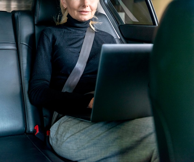 Vista frontal de la mujer de negocios mayor que trabaja en la computadora portátil en el cuidado