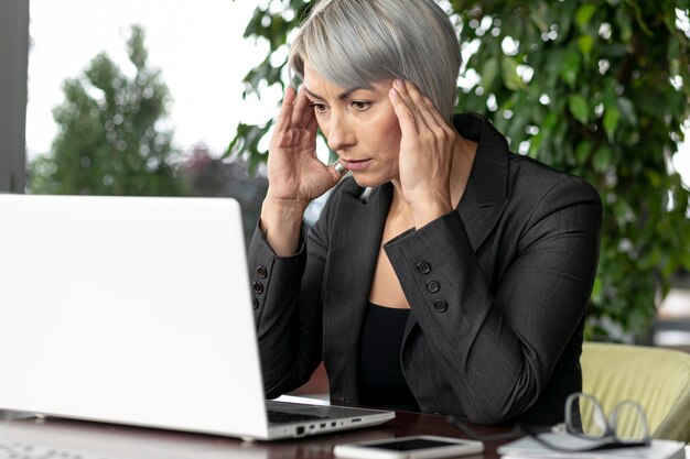 Vista frontal mujer de negocios mirando portátil