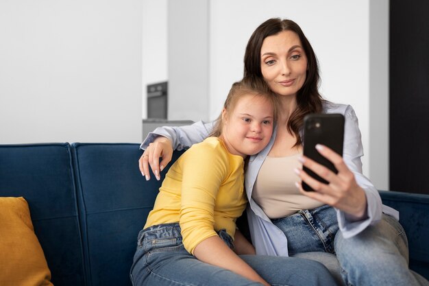 Vista frontal mujer y niña tomando selfie