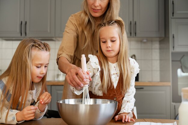 Vista frontal mujer y niños cocinando