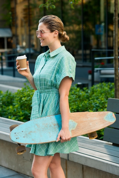 Foto gratuita vista frontal de la mujer con patineta